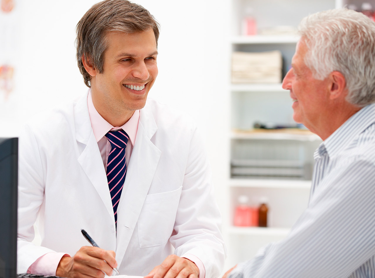 Médico hablando con paciente y sonriendo